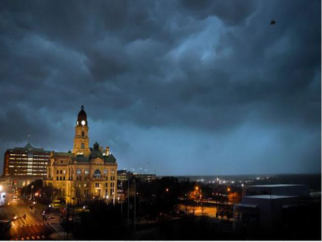 Debris flies through the air as howling winds accompanied by a line of storms approach the old Tarrant County Courthouse in downtown Fort Worth, Texas, on March 2, 2023. (Tom Fox/The Dallas Morning News via AP)