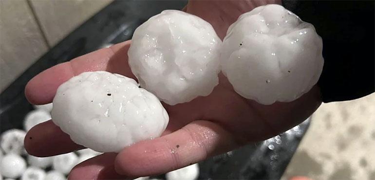 In this image provided by Jeremy Crabtree, large chunks of hail are shown, Wednesday night, March 13, 2024, in Shawnee, Kan. (Jeremey Crabtree via AP)