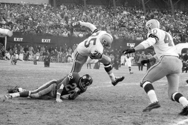 In this Dec. 30, 1962, file photo, Green Bay Packers halfback Tom Moore (25) is stopped by New York Giants` Dick Lynch (22) after returning a kickoff 30 yards in third quarter of the NFL Championship game at New York`s Yankee Stadium. Green Bay won 16-7. (AP Photo/File)